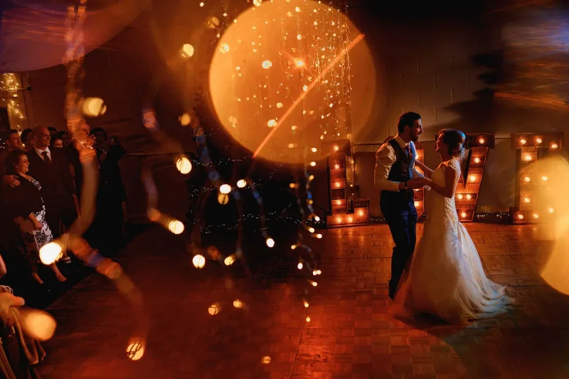Candid wedding photo of a first dance with twinkling fairy lights by wedding photographer ARJ Photography®