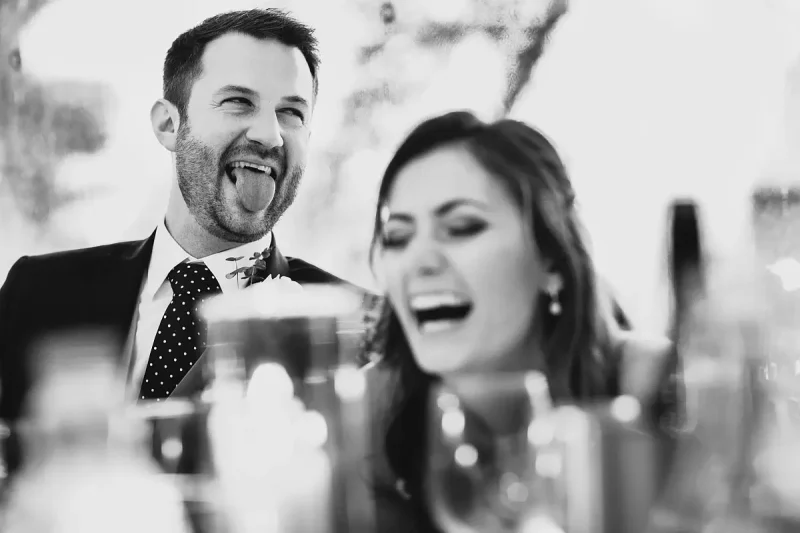 Candid wedding photo of a groom sticking his tongue out during the wedding speeches by wedding photographer ARJ Photography®