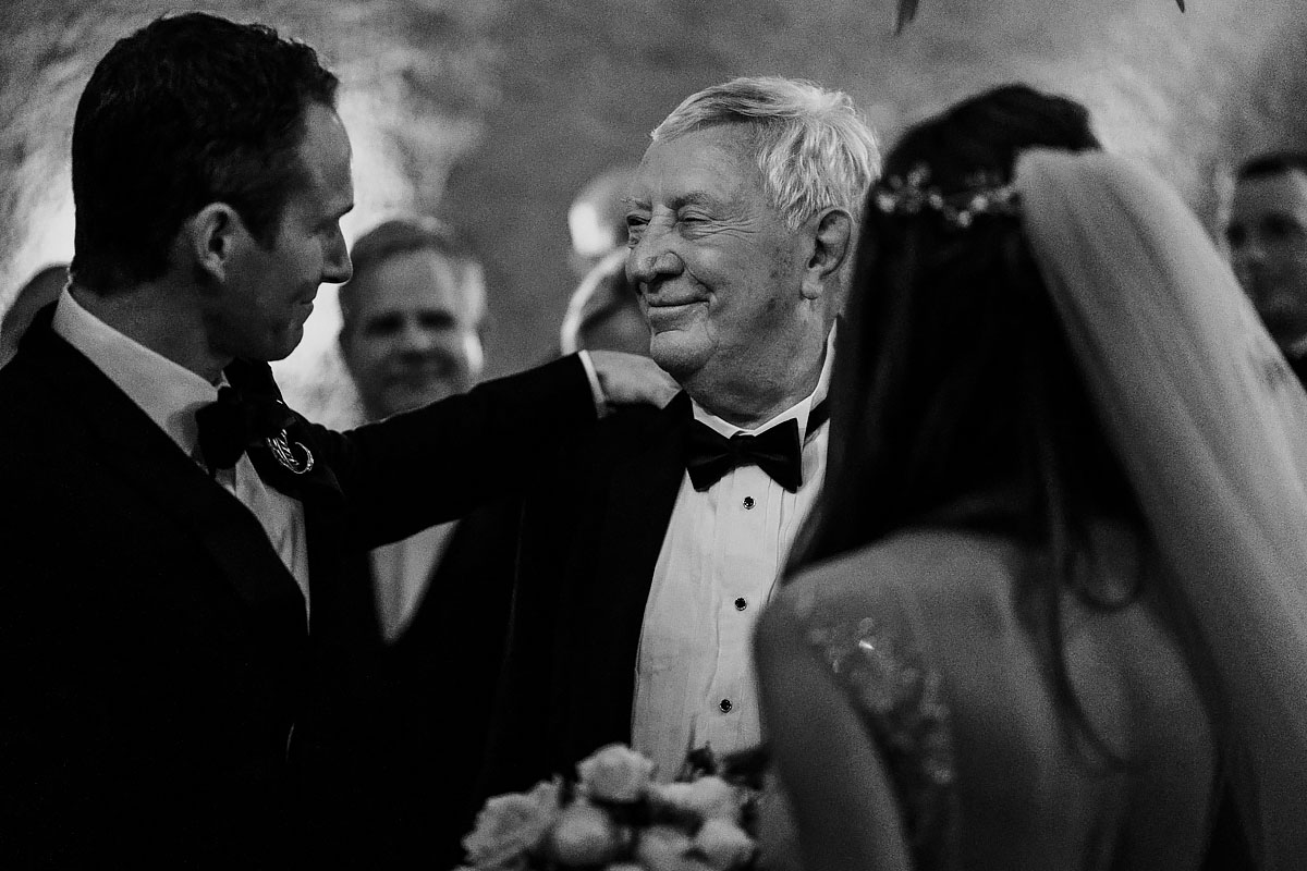A touching moment between the groom and father of the bride at this destination wedding in Napa California - powerful black and white wedding photography by ARJ Photography®