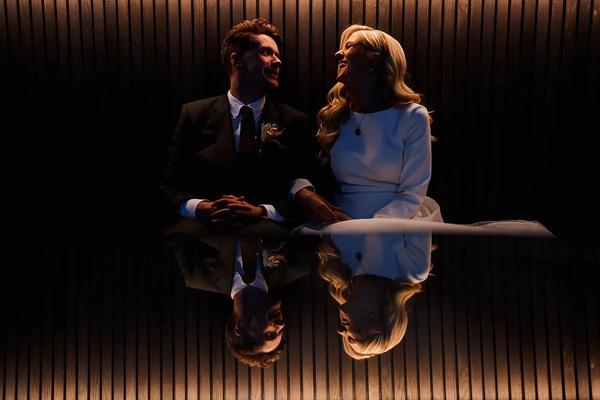 Bride and groom laughing and reflected - artistic wedding photography by ARJ Photography®