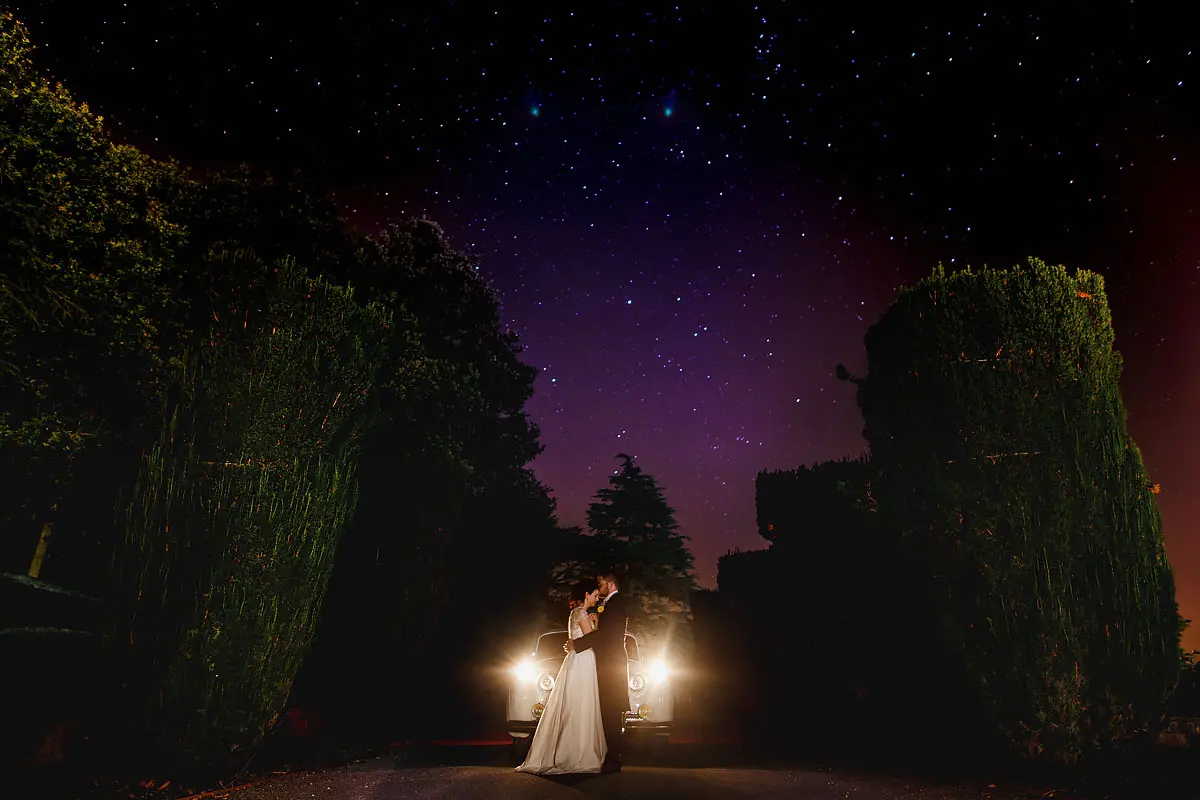 Bride and groom under a colourful starry night sky - artistic wedding photography by ARJ Photography®