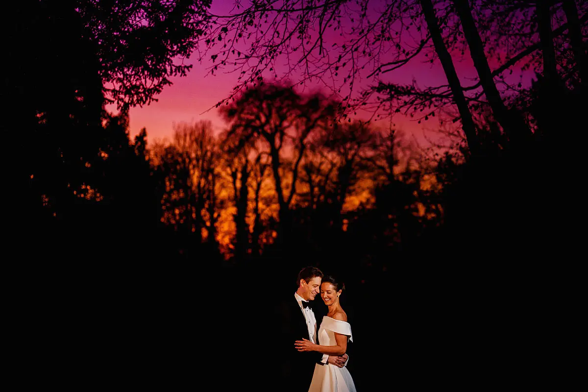 Photo of a bride and groom at a wedding under a colourful night sky - artistic wedding photography by ARJ Photography®