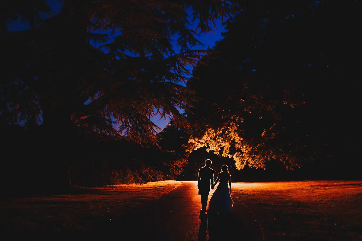 Colourful night time portrait of a bride and groom creating a silhouette - artistic wedding photography by ARJ Photography®