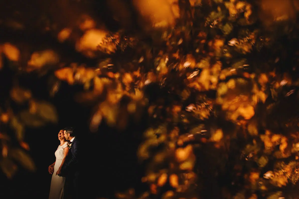 A happy laughing bride and groom creatively framed - artistic wedding photography by ARJ Photography®