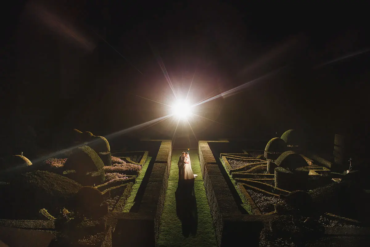 A creative night time wedding portrait of a bride and groom in a topiary garden - artistic wedding photography by ARJ Photography®