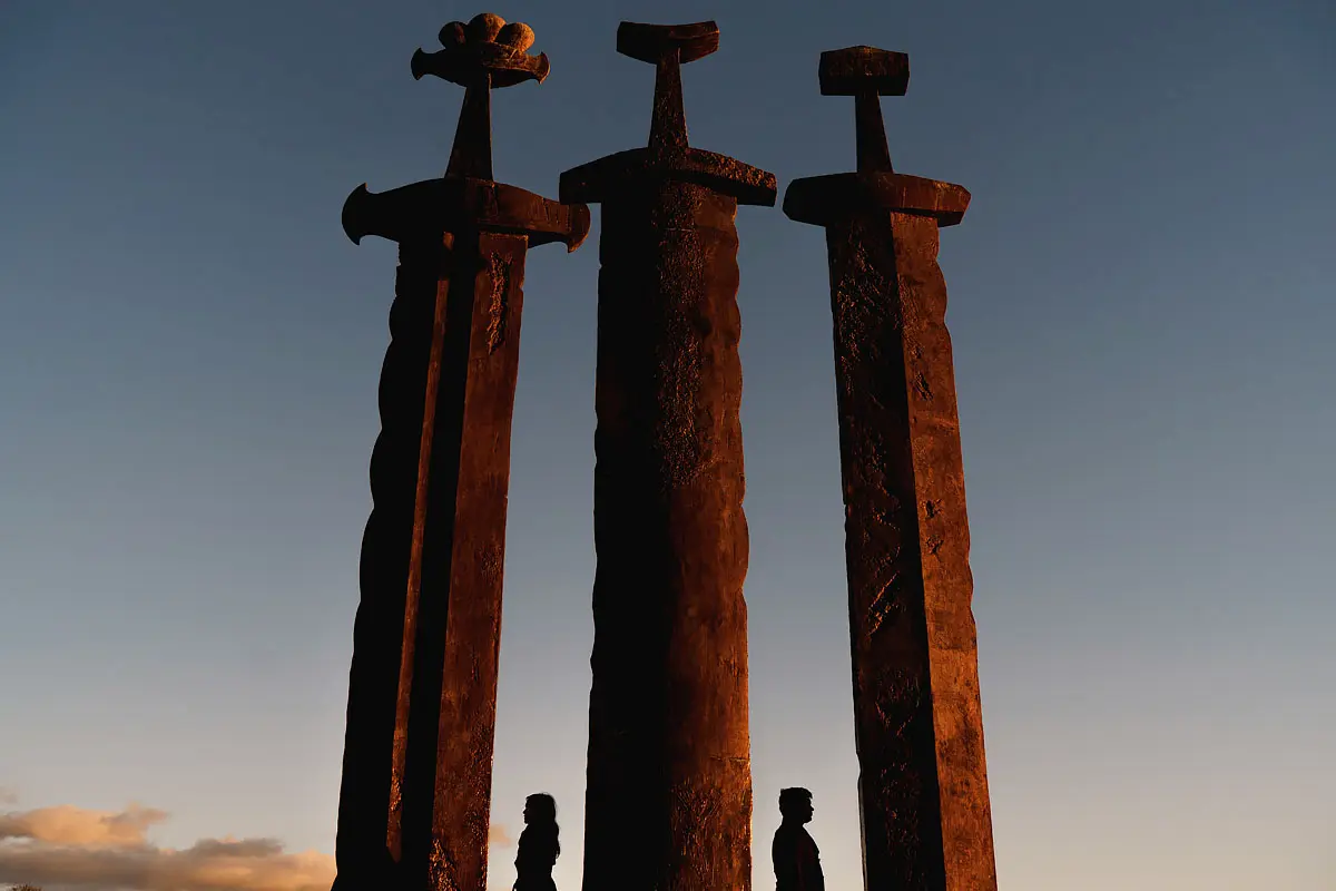A creative wedding portrait of a bride and groom silhouetted between massive swords in Stavanger Norway - artistic wedding photography by ARJ Photography®