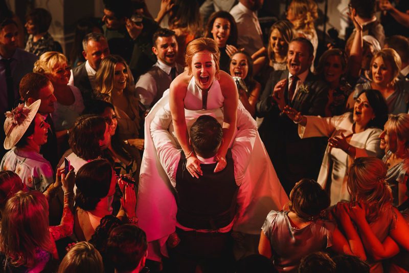 A groom lifts up the bride during their first dance at a wedding party in Liverpool - epic wedding party photo by ARJ Photography®