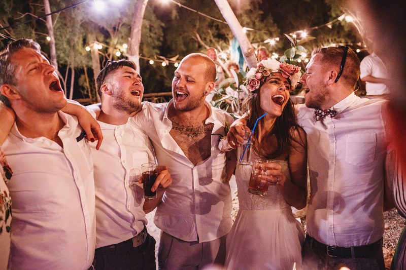 A fun scene as the bride and groom and their guests sing to each other on the dance floor at a destination wedding in Rhodes Greece - epic wedding party photo by ARJ Photography®