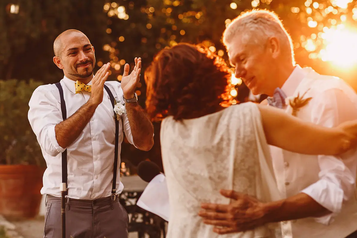 An emotional groom applauds the speech by his father in law at a destination wedding in Tuscany Italy by destination wedding photographer ARJ Photography®