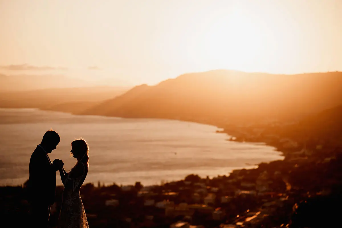 Destination wedding silhouette photo of a bride and groom above the town of Pefkos in Rhodes Greece by destination wedding photographer ARJ Photography®