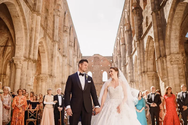 A lovely moment between a bride and groom during a destination wedding ceremony at San Galgano Abbey in Tuscany Italy by destination wedding photographer ARJ Photography®