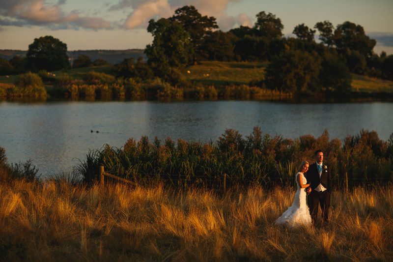 Painterly portrait of a bride and groom surrounded by nature and a lake during their Cheshire wedding - incredible wedding portraits by ARJ Photography®