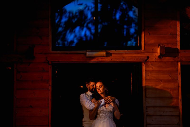 Creative portrait of a bride and groom in the doorway of their wedding venue at sunset - incredible wedding portraits by ARJ Photography®