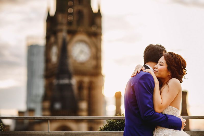 Rooftop wedding portrait of a bride and groom hugging with a clocktower in the background - incredible wedding portraits by ARJ Photography®