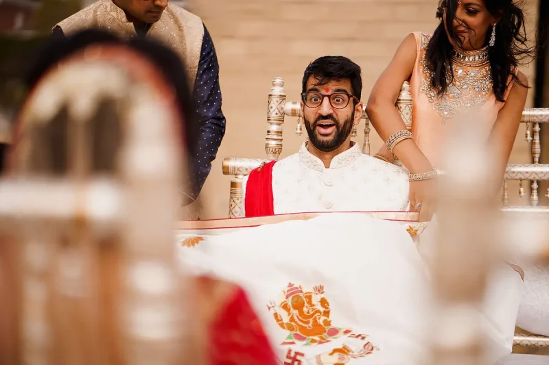 A look of surprise from this groom during a Hindu wedding ceremony as he sees his bride for the first time - Unique Indian wedding photos by ARJ Photography®