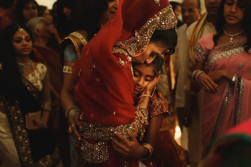 A very precious moment between the bride and her niece during the vidai at a Hindu wedding - Unique Indian wedding photos by ARJ Photography®