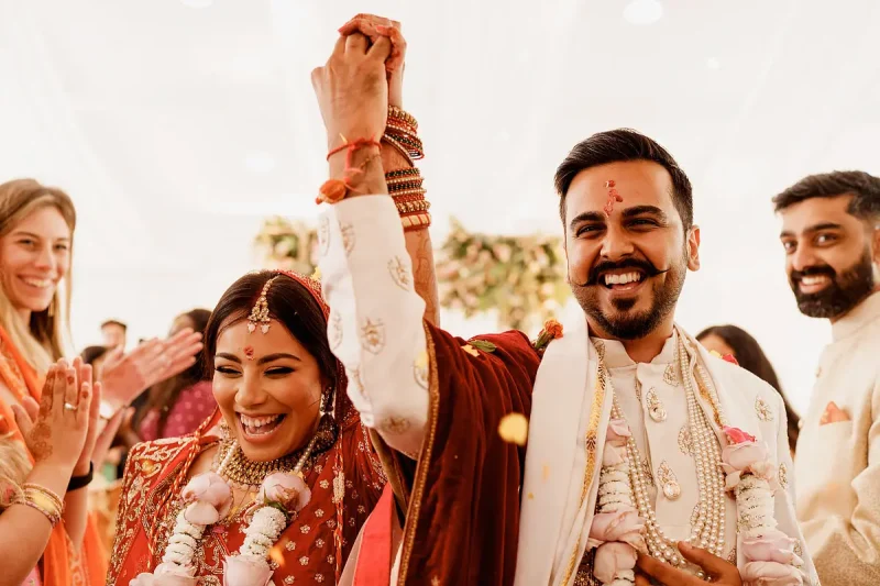 Cheers from the bride and groom during a happy vidai of a Hindu wedding - Unique Indian wedding photos by ARJ Photography®